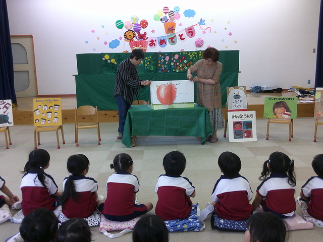 6月絵本の読み聞かせ大きなサイズの絵本を読んでもらっている所