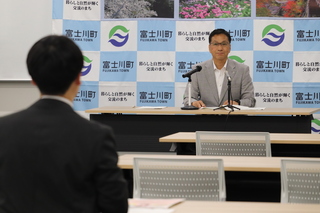 望月町長が記者からの質問を聞いている様子