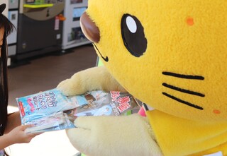 子どもに啓発品を渡すゆずにゃん