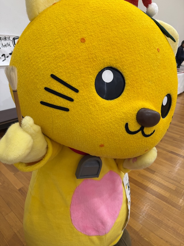 筆を掲げて写真を撮るゆずにゃん