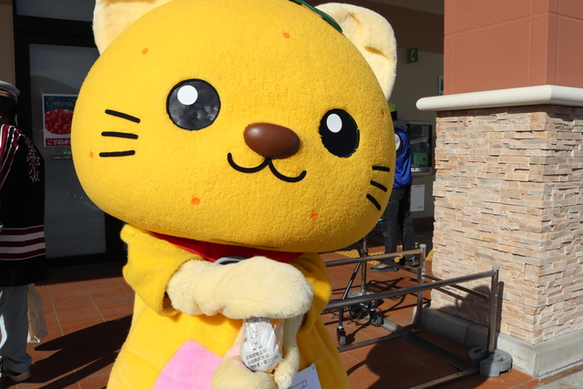 啓発品を渡すゆずにゃん 啓発品を渡すゆずにゃん