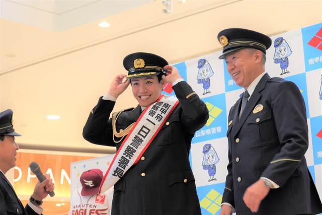 にこにこして警察の帽子をかぶる中込選手