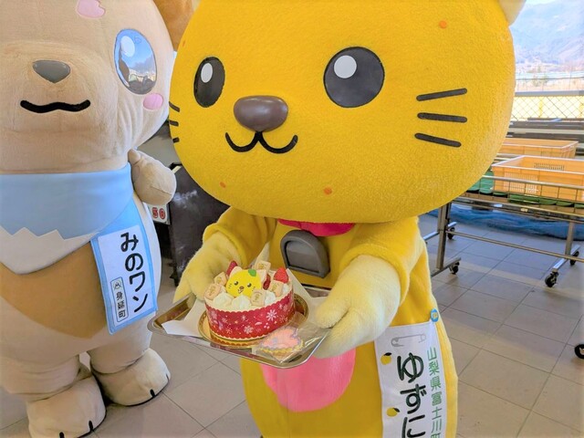 ゆずにゃんがお誕生日ケーキを手に持つ様子